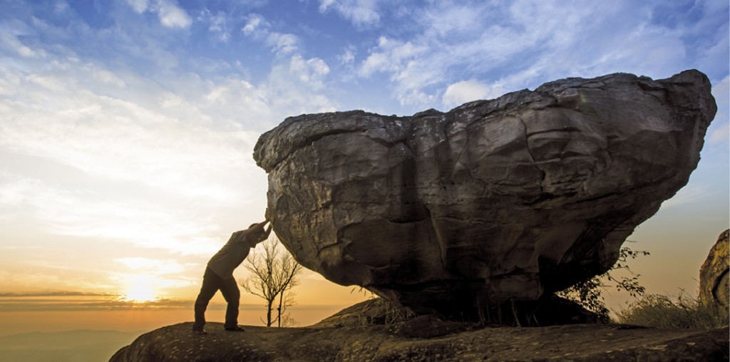 bigstock-Man-pushing-a-boulder-on-a-mou-56958671